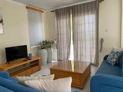 a living room with a blue couch and a tv at Villas Ithaca Protaras in Protaras
