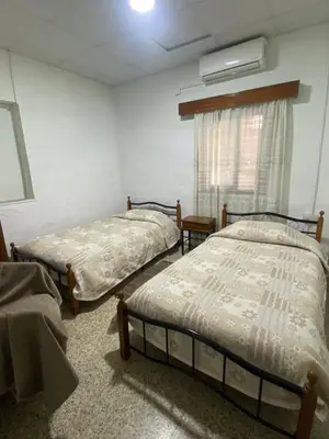 two beds sitting in a room with a window at Christos House in Kakopetria