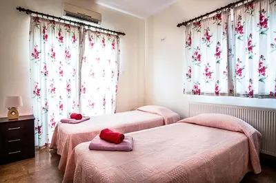 two beds in a room with red pillows on them at Villa Eva in Ayia Napa
