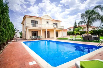 a villa with a swimming pool in front of a house at Villa Eva in Ayia Napa