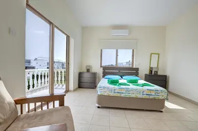 a bedroom with a bed and a balcony at Villa Eva in Ayia Napa