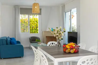 a living room with a table and a blue couch at Fig Tree Bay Villa 3 in Protaras
