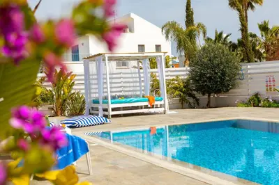 a swimming pool with a swing next to a house at Fig Tree Bay Villa 3 in Protaras