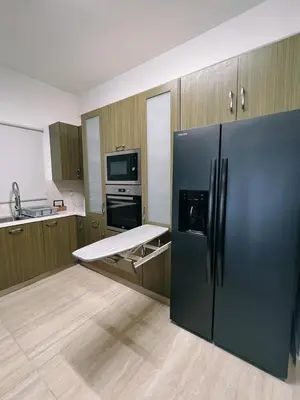 a kitchen with a black refrigerator and a stove at Oasi Rejuve Villa in Meneou