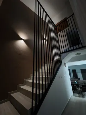 a staircase with black railings in a house at Oasi Rejuve Villa in Meneou