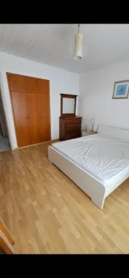 a bedroom with a white bed and a wooden floor at Luxury Apartment Ayia Napa Center in Ayia Napa