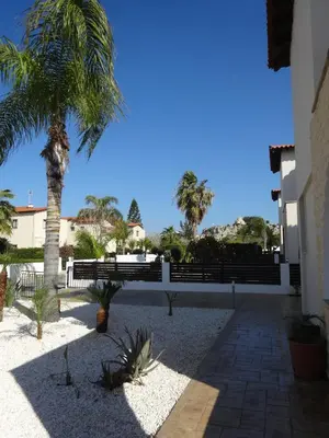 a courtyard with a palm tree and a fence at Cy-Blue in Protaras