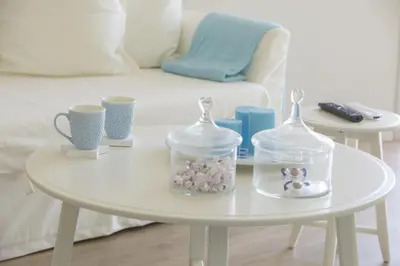 a white table with glass containers of beads and cups at Azure Beachfront Suite in Protaras