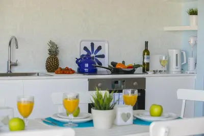 a kitchen with a table with glasses of orange juice at Azure Beachfront Suite in Protaras