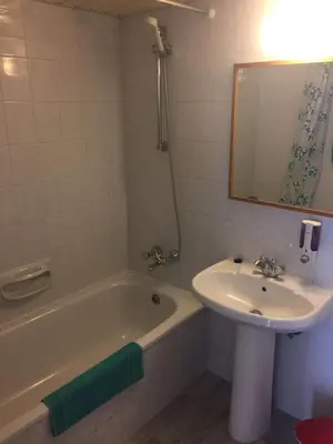 a bathroom with a sink and a tub and a mirror at Nautilus Tourist Apartments in Larnaka