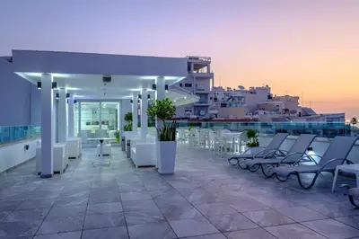 a row of white chairs and tables on a balcony at Art & Wine Boutique Hotel in Larnaka