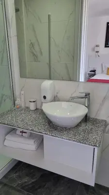 a bathroom counter with a sink and a mirror at Art & Wine Boutique Hotel in Larnaka
