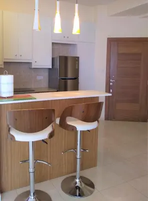 a kitchen with a counter and two bar stools at T&E Apartment in Larnaka