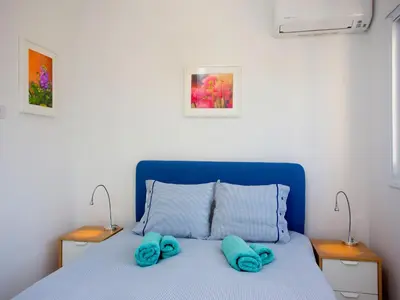 a bedroom with a blue bed with two towels on it at On The Beach Penthouse by TrulyCyprus in Limassol