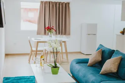 a living room with a blue couch and a table at Stephanie Studios in Larnaka