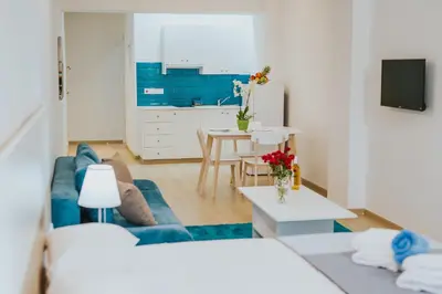 a living room with a blue couch and a table at Stephanie Studios in Larnaka