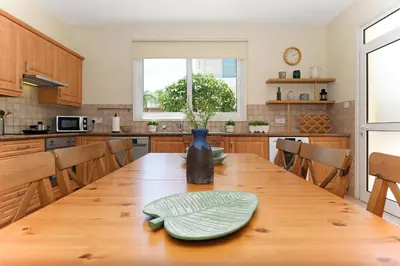 a kitchen with a wooden table with a vase on it at Villa Celine in Protaras