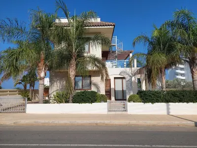 a white house with palm trees in front of it at Villa Sotmarie in Protaras