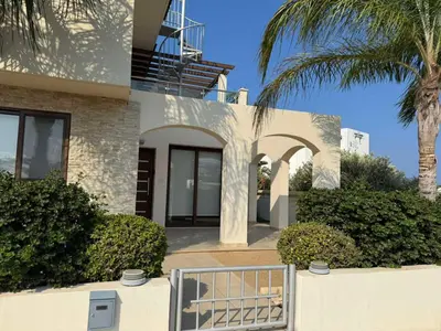 a white house with a palm tree and a fence at Villa Sotmarie in Protaras