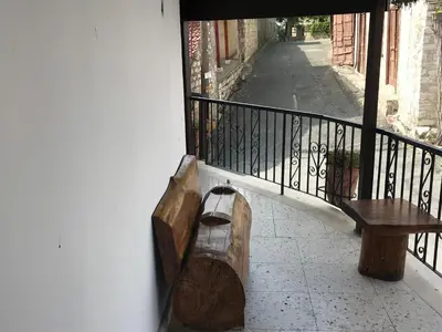 a balcony with a wooden bench and a railing at Xenios Guesthouse in Koilani