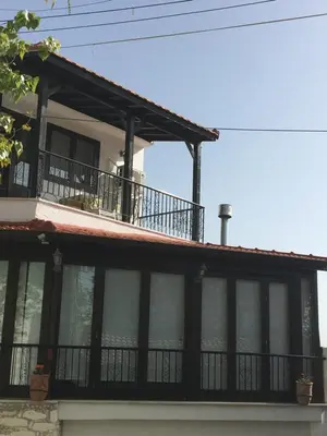 a house with a balcony on top of it at Xenios Guesthouse in Koilani