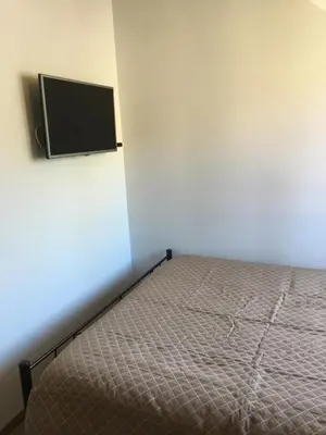 a bedroom with a bed and a flat screen tv at Xenios Guesthouse in Koilani