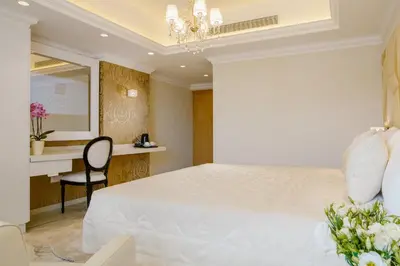 a bedroom with a white bed and a desk at Qbic City Hotel in Larnaka
