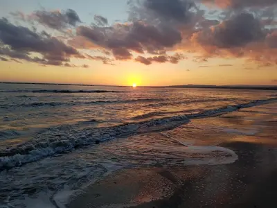 a sunset on a beach with the ocean at Periyiali Beach Sunset Suite A7 in Pervolia