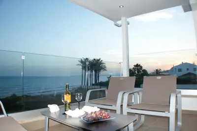 a room with a table and chairs and a view of the ocean at Periyiali Beach Sunset Suite A7 in Pervolia