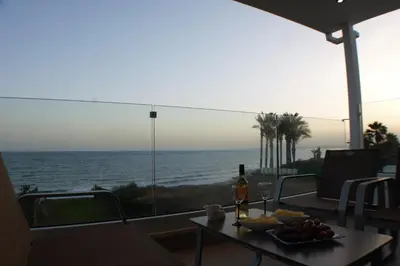 a table with a plate of fruit and a bottle of wine at Periyiali Beach Sunset Suite A7 in Pervolia