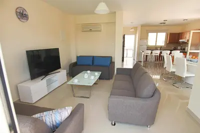 a living room with couches and a flat screen tv at Casa Di Kappari in Protaras