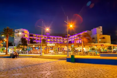 a building with purple lights on it at night at Limanaki Beach Hotel & Suites in Ayia Napa