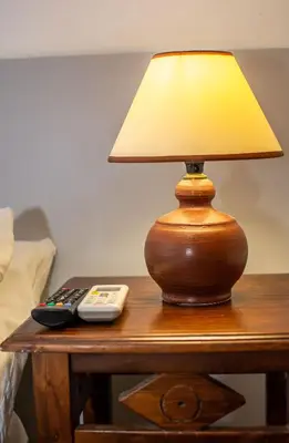 a lamp sitting on a table with a remote control at Marina's Rooms in Larnaka