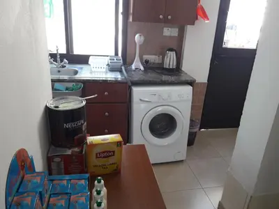 a kitchen with a washing machine and a sink at Marina's Rooms in Larnaka