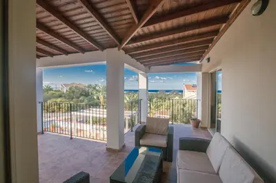 a porch with a couch and chairs on a balcony at Villa Orka in Protaras