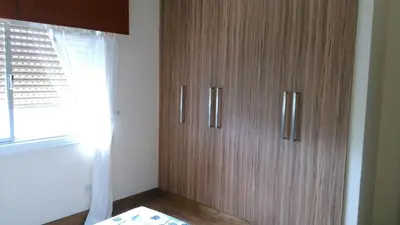 a wooden cabinet in a room with a window at Modern City Center Apt in Larnaka