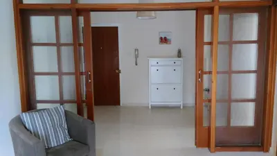 a living room with a chair and sliding glass doors at Modern City Center Apt in Larnaka