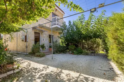 a house with a gravel driveway in front of it at The River House in Trimiklini