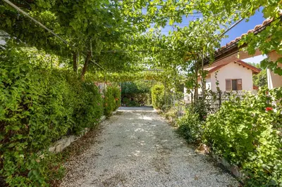 a garden path leading to a house at The River House in Trimiklini