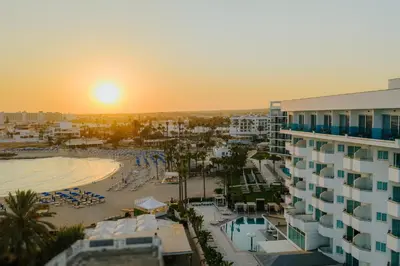 a view of a hotel and a beach at sunset at Tasia Maris Sands (Adults Only) in Ayia Napa