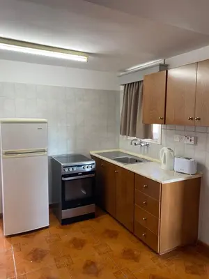a kitchen with a white refrigerator and a stove at Alexia Hotel Apartments in Ayia Napa