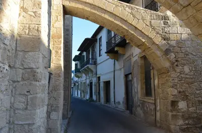 an alley with an archway in a stone building at Alkisti City Hotel in Larnaka