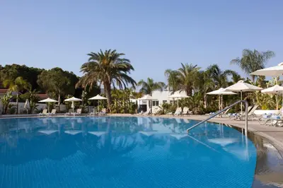 a large blue swimming pool with umbrellas and chairs at Christofinia Hotel in Ayia Napa