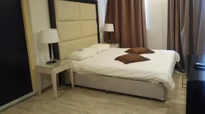 a bedroom with a bed and a table with a lamp at Castelli Hotel Nicosia in Nicosia