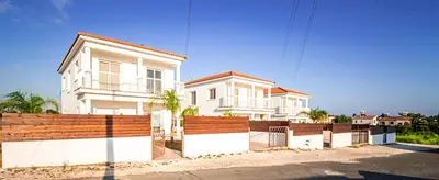 a white house with a fence in front of it at Nissi Villa Gintare in Ayia Napa