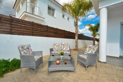 a patio with two chairs and a table at Nissi Villa Christa in Ayia Napa