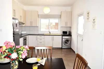 a kitchen with a table with a vase of flowers at Nissi Villa Christa in Ayia Napa