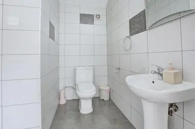 a white bathroom with a toilet and a sink at Nissi Villa Christa in Ayia Napa