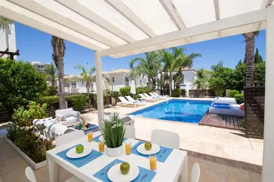 a patio with a table and chairs and a swimming pool at Villa Mylos 7 in Protaras
