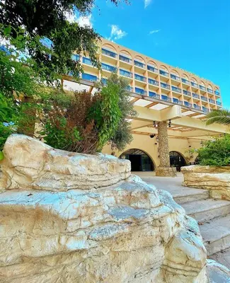 a large building with a stone wall in front of a building at Navarria Blue Hotel in Limassol
